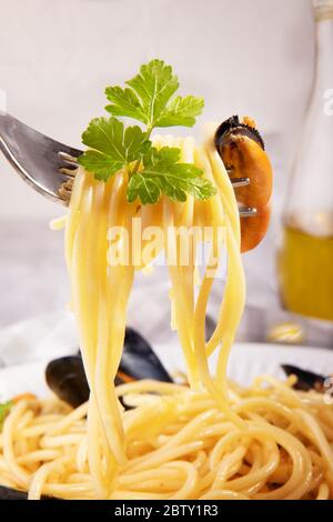 Spaghetti wrapped in a fork with mussel, close-up of popular italian pasta spaghetti with mussel from Taranto Stock Photo