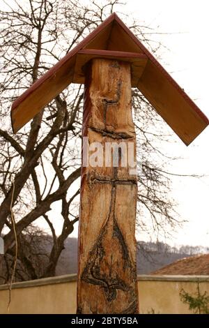 Piece of wood with natural cross design on it displayed in the courtyard of a church in Romania Stock Photo
