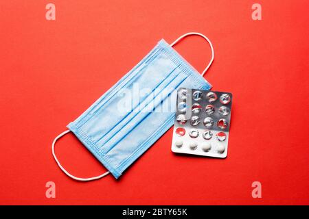 Prevent coronavirus. Medical mask, Medical protective mask isolated on red background. Disposable surgical face mask cover mouth and nose. Healthcare Stock Photo