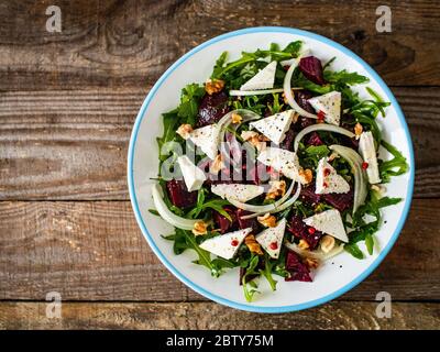Salad with beet, feta cheese and walnuts  on wooden background Stock Photo
