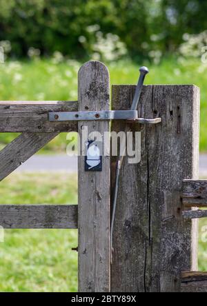 A wooden gate post with latched gate on the Yorkshire Wolds Way with acorn sign. Stock Photo