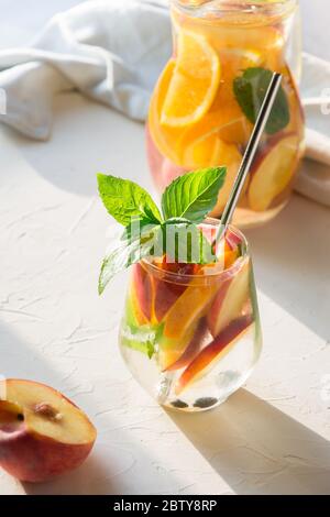 Freshness peach lemonade in glass garnish mint on light background. Summer healthy drink. Vertical. Stock Photo