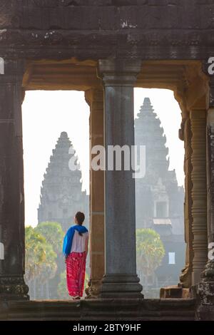 A tourist gazing out at Angkor archaeological complex, UNESCO World Heritage Site, Siem Reap, Cambodia, Indochina, Southeast Asia, Asia Stock Photo