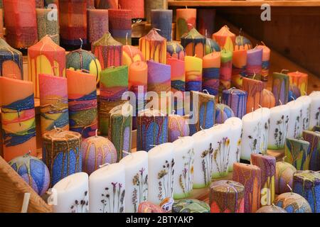 https://l450v.alamy.com/450v/2btyakp/many-multicolored-colorful-red-orange-yellow-paraffin-stick-candles-arranged-in-black-shelves-lying-on-shelter-and-sorted-by-color-in-a-household-cand-2btyakp.jpg