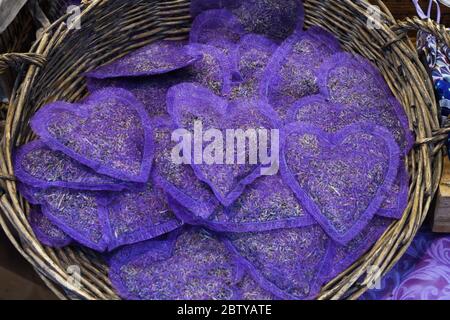 Group of delicate dried lavender bouquets with lila textile material, displayed for sale at an weekend deco fair for handmade artisans, selective focu Stock Photo