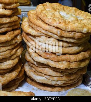 Homemade traditional hungarian dish named "langosi" during food festival, freshly baked or deep fried stack of doughnuts, on a plate, on a rustic napk Stock Photo