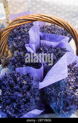 Group of delicate dried lavender bouquets with lila textile material, displayed for sale at an weekend deco fair for handmade artisans, selective focu Stock Photo
