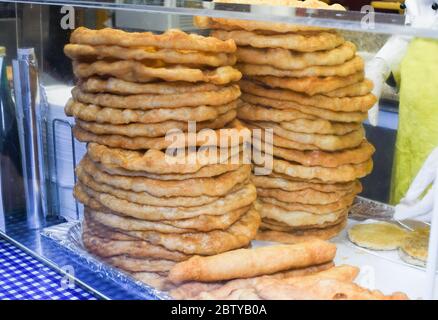 Homemade traditional hungarian dish named "langosi" during food festival, freshly baked or deep fried stack of doughnuts, on a plate, on a rustic napk Stock Photo