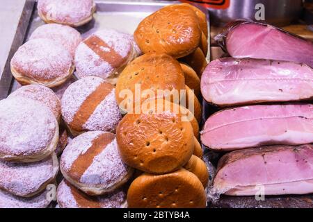 Many homemade German mix of meat specialties, speck ham sausages pile or stack on counter top, for sale, during food festival, outdoor outside marketp Stock Photo