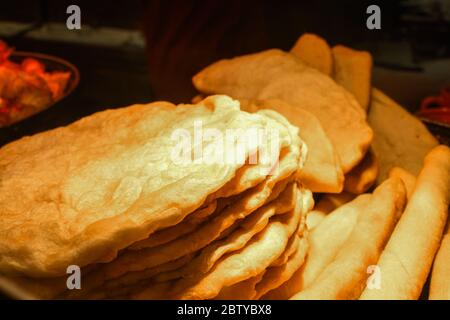 Homemade traditional hungarian dish named "langosi" during food festival, freshly baked or deep fried stack of doughnuts, on a plate, on a rustic napk Stock Photo