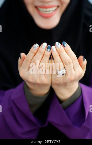 Asian Muslim woman praying, The National Mosque (Masjid Negara), Kuala Lumpur, Malaysia, Southeast Asia, Asia Stock Photo