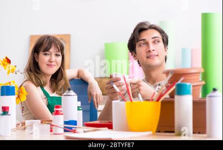 The couple decorating pots in workshop during class Stock Photo