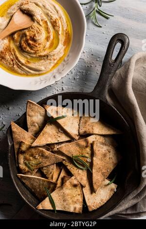 Home made humus bowl, decorated with d olive oil over a rustic wooden clear background. Top View