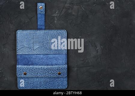Blue leather wallet on a black textured background. Stock Photo