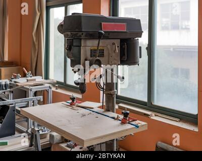 SHANGHAI, CHINA - NOVEMBER 24, 2018. Carpenter's Equipment and Work Bench in Joiner's Wood Shop. Machine for Drilling Woodwork Holes Workshop. Stock Photo