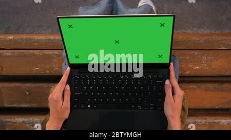 Woman sitting on a bench looking at Laptop screen. Stock Photo