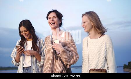 Group of female friends laughing after watching something funny Stock Photo