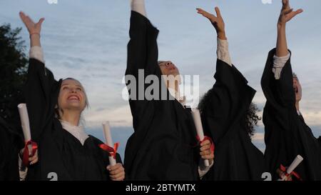Happy and excited mixed ethnicity group of student friends on gr Stock Photo
