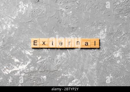 EXTERNAL word written on wood block. EXTERNAL text on cement table for your desing, concept. Stock Photo