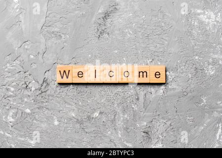 WELCOME word written on wood block. WELCOME text on table, concept. Stock Photo