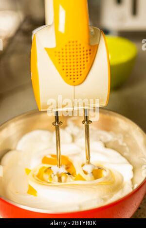 Beating a white cream with a mixer in a metal bowl. Whipped cream. Cream  for the cake Stock Photo - Alamy