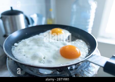 2 scrambled eggs on the pan. On the gas cylinder. Close up. Stock Photo