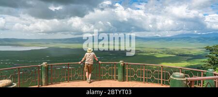 Tourist looks into the Ngorongoro crater National Park with the Lake Magadi from the look out.  Beautiful landscape scenery in Tanzania, Africa Stock Photo