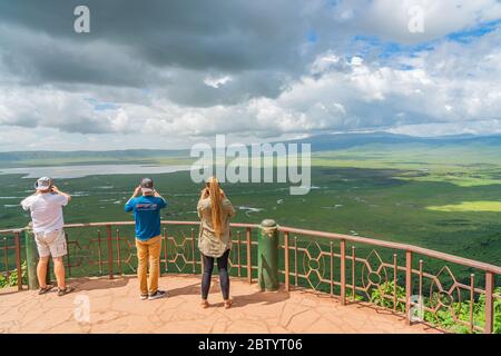 Tourist looks into the Ngorongoro crater National Park with the Lake Magadi from the look out.  Beautiful landscape scenery in Tanzania, Africa