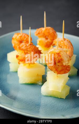 Canapes with shrimp and pineapple. Party food. Dark background. Stock Photo