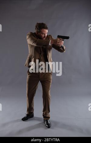 Isolated image of an undercover cop with a gun against a plain background, ideal for ebook cover design and book jackets Stock Photo