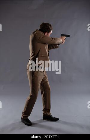 Isolated image of an undercover cop with a gun against a plain background, ideal for ebook cover design and book jackets Stock Photo