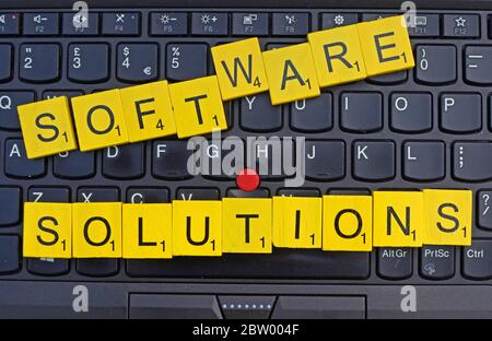 Software Solutions, spelt out in scrabble letters on a keyboard, software houses,Enterprise Software Solutions, business software,SME Solutions Stock Photo