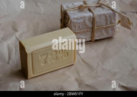 Pieces of laundry soap on a plain background. Two rectangular pieces of new soap wrapped with twine. Natural hygiene products. Place for text. Selecti Stock Photo