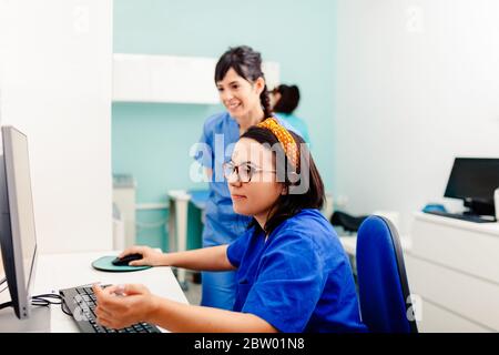 Two nurses using a computer in a x-ray room Stock Photo
