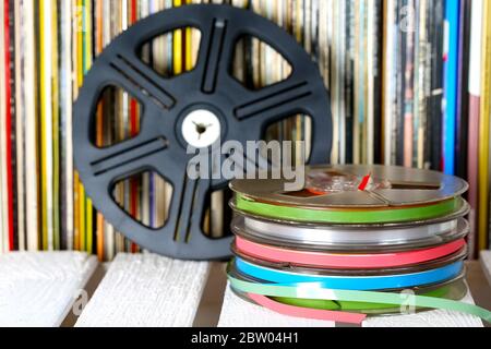 Several sound recording tapes are shown on the background of vinyl records Stock Photo