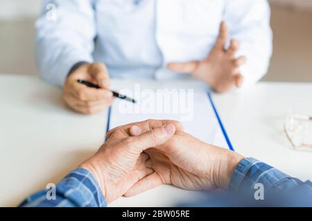 Patient and doctor. The doctor tells the patient about his illness and the possibilities of his medical insurance. Health Care Concept. Stock Photo