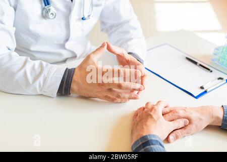 Hands close up - the doctor tells the patient about his illness and the possibilities of his insurance. Stock Photo