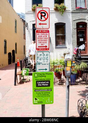 Street signs on one pole; No Parking, two away, 1 hour parking, in Eastern Market section of Washington, D.C. Stock Photo