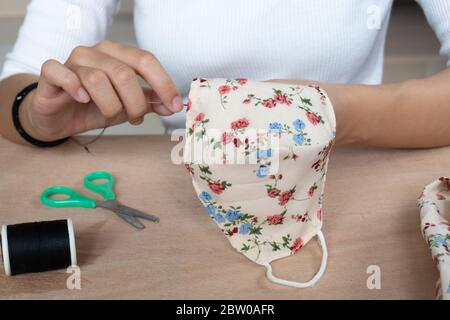 Making DIY masks at home sewing fabric mask handmade cotton protective equipment. Stock Photo