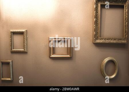Empty golden luxury frames on vintage design wall, space for text. antique luxe interior Stock Photo