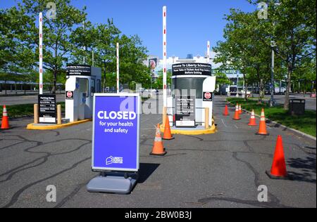 The sign of Closed for your health and safety by the entrance of empty parking lot of Liberty Science Center during the outbreak of Coronavirus pandemic.Liberty Science Center.Jersey City.New Jersey.USA Stock Photo