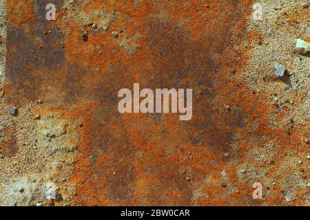 Iron leaf covered with strong deep red and brown rust with sand and stones. The texture of corrosion, wear and destruction. Place for text and background for design. Stock Photo