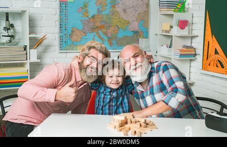 Happy boy hugging Father and Grandfather. Delighted cute son hugging his father and grangfather Stock Photo