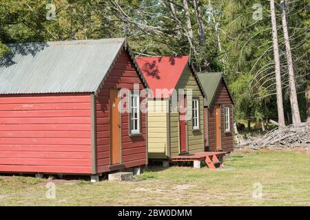 Wooden holiday chalets on a campsite in Manapouri New Zealand Stock Photo
