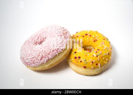 Closeup of delicious sweet glazed donuts with flakes with a white background. Stock Photo