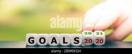Hand turns dice and changes the expression "goals 2020" to "goals 2021" Stock Photo