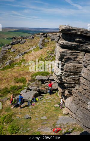 View from Bamford Edge toward Ladybower Reservoir with people sitting/climbing/ enjoying the day after coronavirus lockdown has been eased Stock Photo