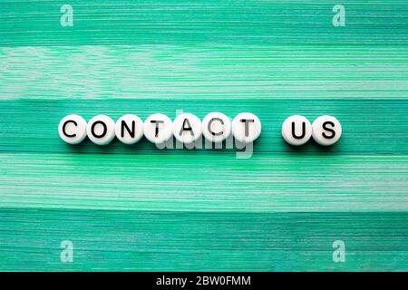 Contact us text on a green wooden table Stock Photo