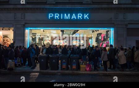 Primark shop on Oxford Street at night with lots of shoppers coming out of the store. London Stock Photo