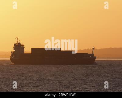 Sheerness, Kent, UK. 28th May, 2020. UK Weather: shipping on the Thames passes the sunset as seen from Sheerness in Kent. Credit: James Bell/Alamy Live News Stock Photo